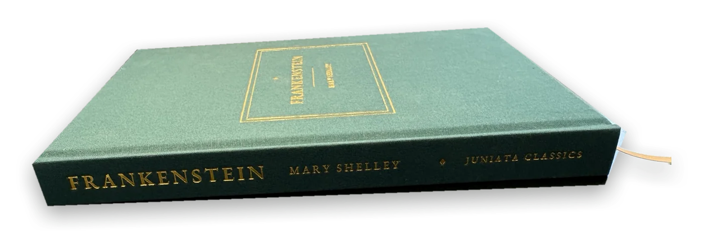 Frankenstein lying flat, showing the gold-stamped spine: Frankenstein, Mary Shelley, Juniata Classics.